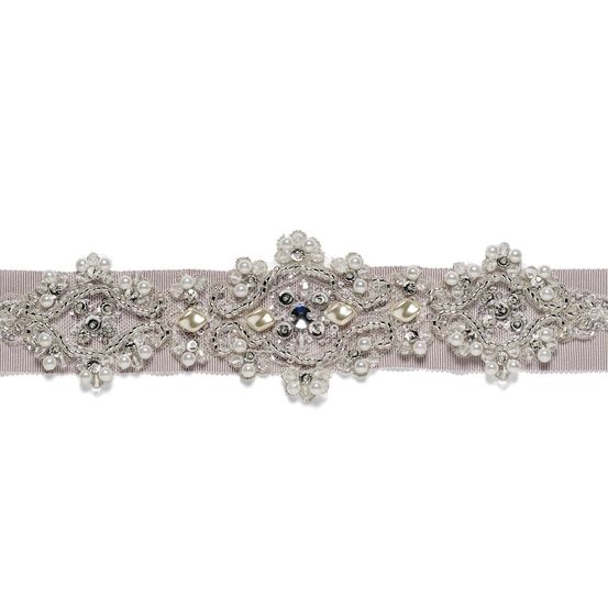 Ein weißer Gürtel mit silbernen und perlenartigen Designs auf weißem Hintergrund.