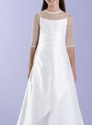 Ein junges Mädchen trägt ein weißes Kleid mit Spitzenärmeln und steht vor einem lila Hintergrund.