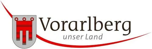 Das Logo der Region Vorarlberg zeigt einen stilisierten Schild mit einem roten und weißen Muster, begleitet von dem Text 'Vorarlberg unser Land' in Schwarz.