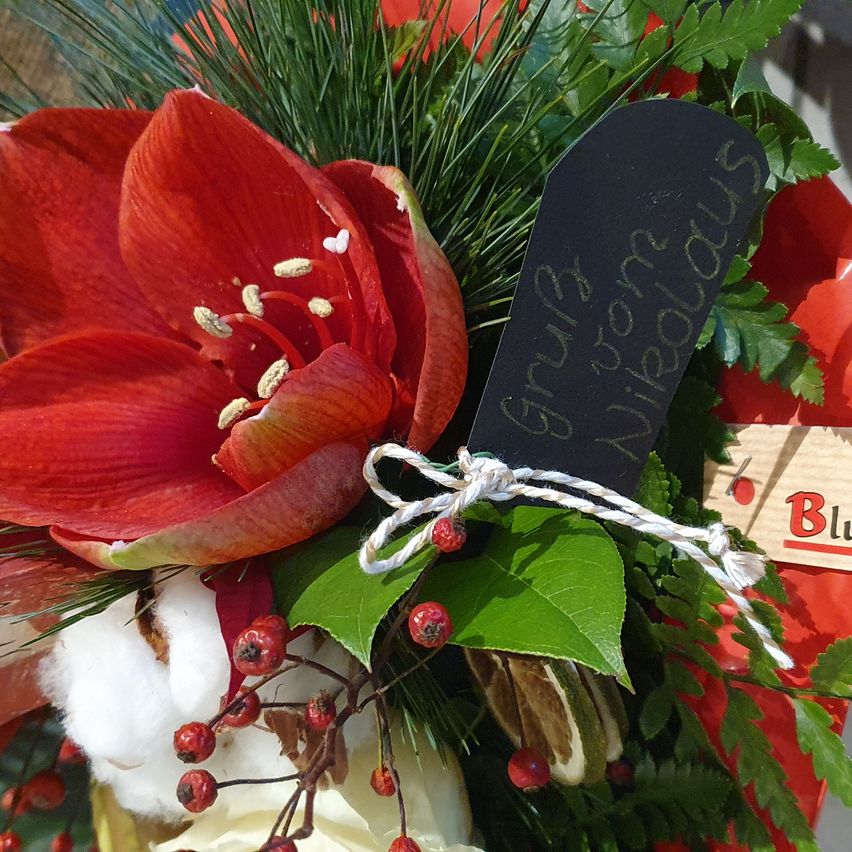 Ein Nahaufnahme einer roten Blume mit einem Schild, das '4328 Pure Marvelous' steht. Die Blume ist mit einem weißen Faden gebunden. Es gibt rote Beeren, grüne Blätter und Baumwolle.