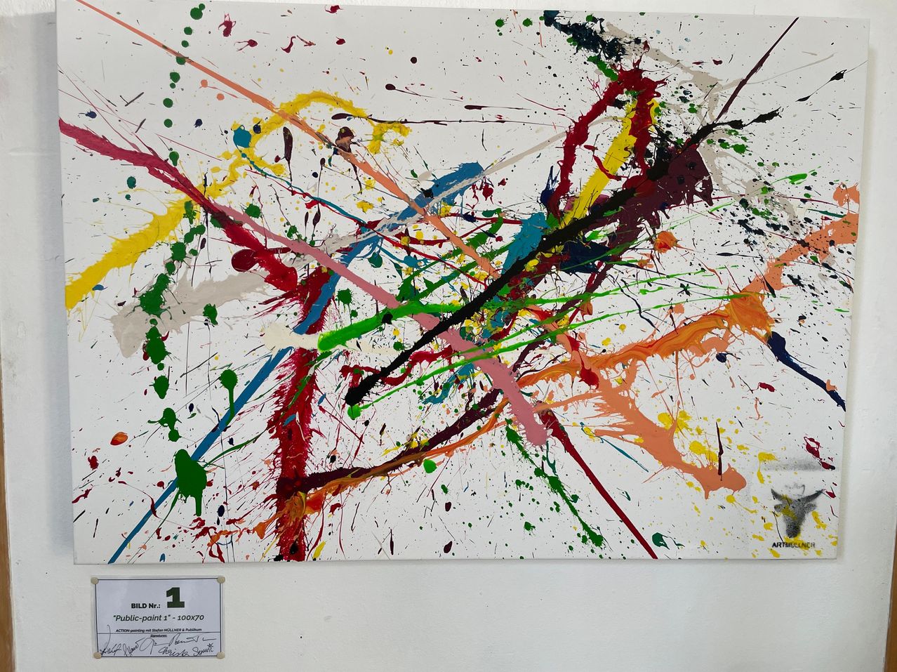 Ein abstraktes Gemälde mit mehreren Farben wie Rot, Blau, Gelb, Grün und Orange. Es hat einen weißen Hintergrund mit einem Etikett am unteren Rand, das 'BILD NR: 1' und 'Public-paint 1' - 100x70 steht. ART ist auch in der oberen rechten Ecke geschrieben.
