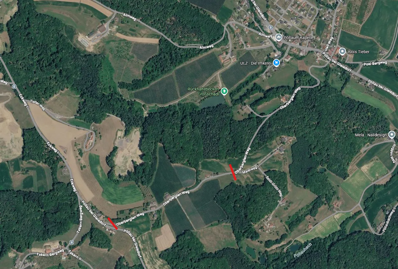 Luftaufnahme eines ländlichen Gebiets mit mehreren Straßen und Feldern. Die Straßen sind mit roten Pfeilen markiert, und das Gebiet ist von Bäumen und Vegetation umgeben.