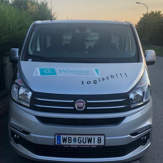 Vorderseite eines silbernen Lieferwagens mit G. Wimmer Logistik darauf. Das Kennzeichen stammt aus Baden, Deutschland.
