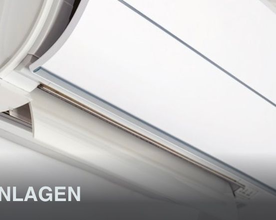 Nahaufnahme einer weißen Klimaanlage, die an einer Decke mit einer silbernen Linie montiert ist und das Wort 'MAANLAGEN' in fetten Buchstaben enthält.