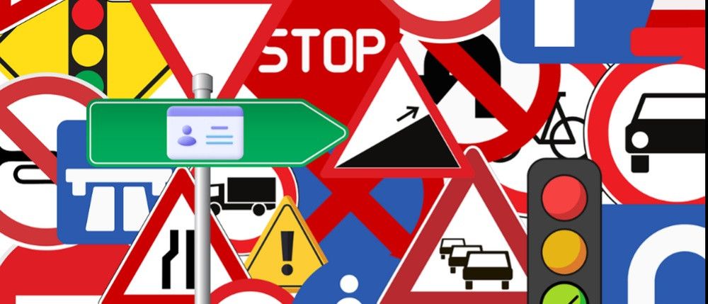 Eine Sammlung verschiedener Verkehrszeichen, einschließlich Stopp-, Vorfahrt und Fußgängerübergangszeichen, auf einem farbenfrohen Hintergrund dargestellt.