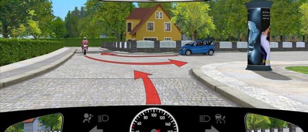 Eine simulierte Fahrszene zeigt einen Motorradfahrer und ein blaues Auto, das links abbiegt, mit einem gelben Haus und Bäumen im Hintergrund.