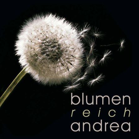 A close-up of a dandelion with its seeds scattered, displayed against a dark background. The text reads 'blumen reich andrea' in white.