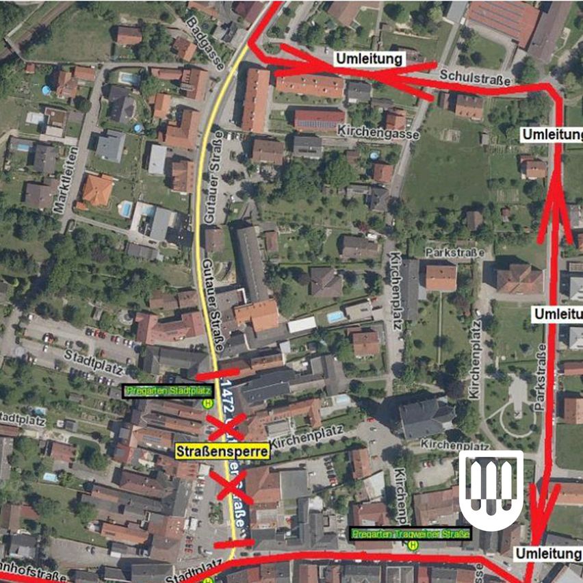 Eine Luftaufnahme einer Stadt mit ausgewiesenen Umleitungsrouten. Rote Linien zeigen die neuen Routen. Die Karte enthält Beschriftungen wie 'Umleitung' und 'Straßensperre', zusammen mit Straßennamen und Orientierungspunkten.