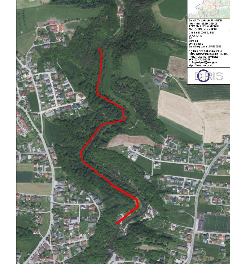 A map shows a village area with a red line indicating a path. The map includes various labels and coordinates. The area is surrounded by trees, with a river flowing through it. There are buildings and a soccer field visible.