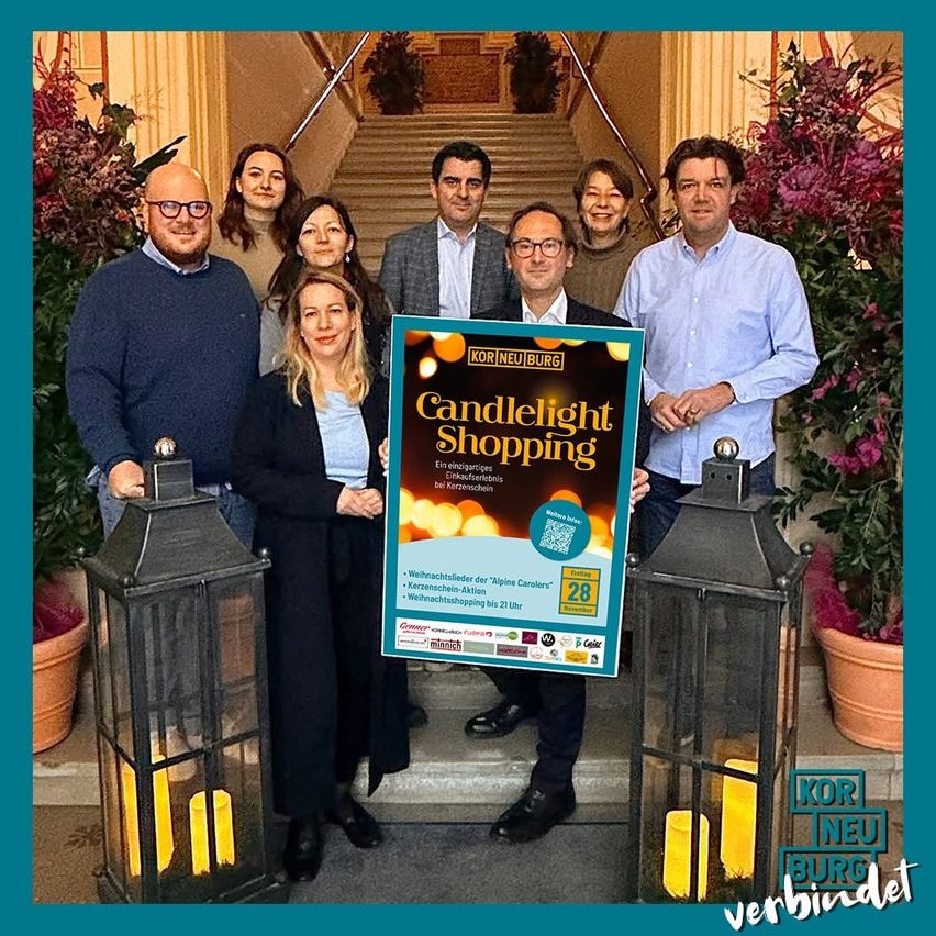 Eine Gruppe von Menschen posiert für ein Foto auf einer Treppe mit einer Laterne und einem Schild, das 'Candlelight Shopping' besagt. Die Veranstaltung findet am Freitag, den 28. November statt.