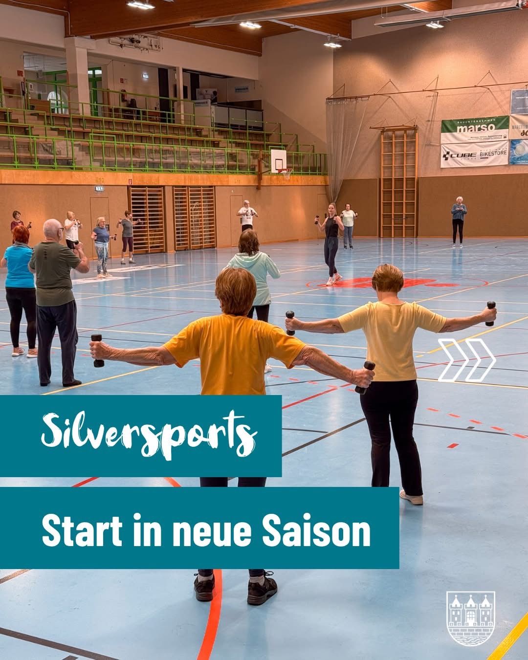 A group of older adults exercise in an indoor gym, holding dumbbells. The court has a basketball hoop and banners on the walls. The text 'Silversports Start in neue Saison' is displayed on a blue background.