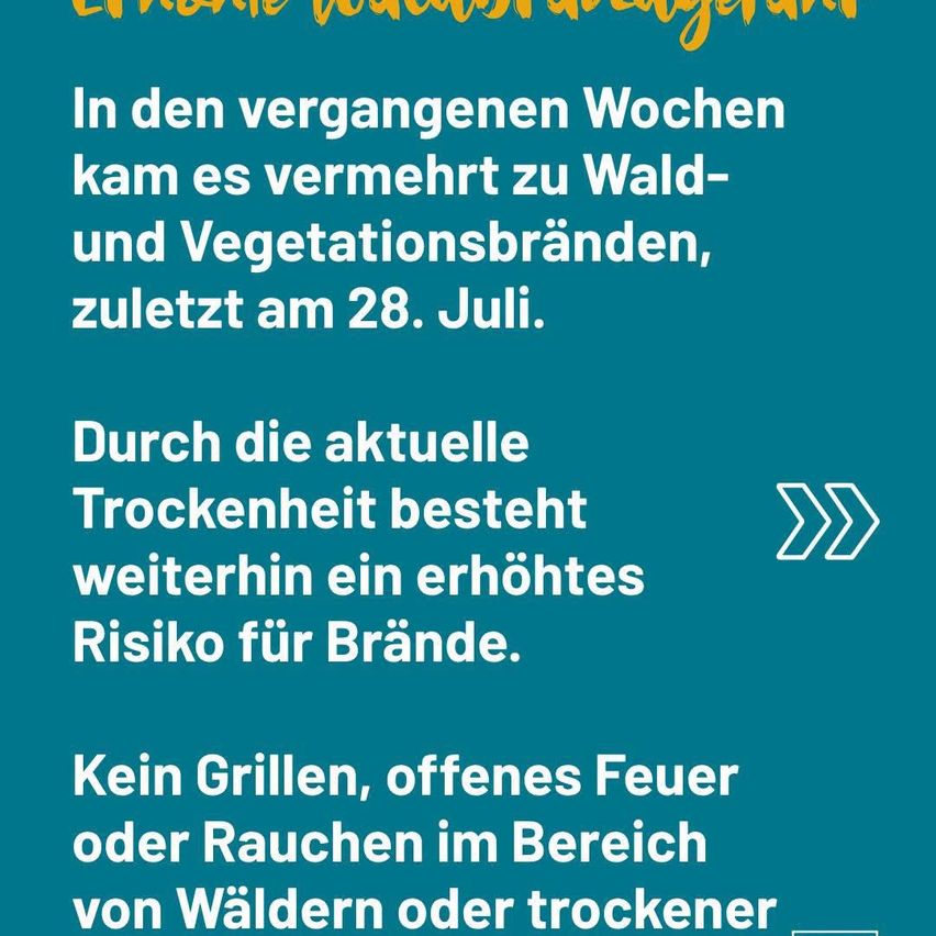 Ein blaues Plakat mit weißem Text warnt vor erhöhter Brandgefahr aufgrund der aktuellen Trockenheit und rät davon ab, in Wäldern oder trockenen Gebieten zu grillen, offenes Feuer zu machen oder zu rauchen.