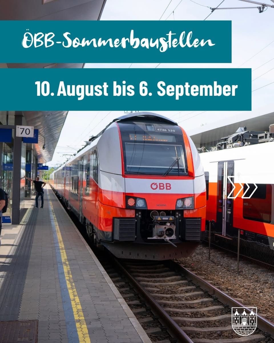 Ein roter und weißer Zug ist auf der Schiene am Bahnhof. Er hat die Nummer 4746 520 auf der Vorderseite. Eine Person steht auf dem Bahnsteig.