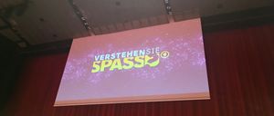 Bild enthält, People, Person, Electronics, Screen, Crowd, Cinema, Business Card, Audience, Projection Screen, Interior Design