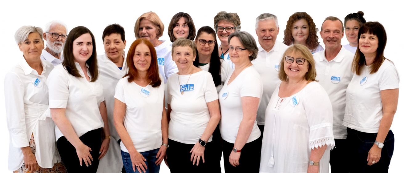 Eine Gruppe von Personen in weißen T-Shirts mit blauen Logos steht zusammen, lächelt und posiert für ein Foto. Sie tragen alle Brillen und Uhren.