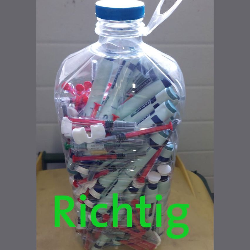 Eine klare Plastikflasche gefüllt mit verschiedenen Stiften und Markern, mit einem blauen Verschluss und unten mit 'Richtig' in Grün beschriftet.