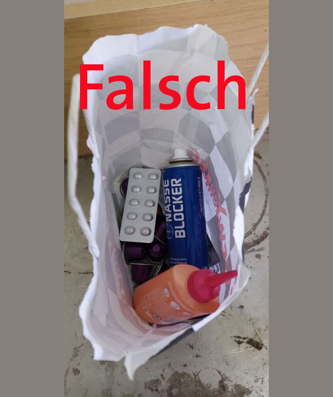 Ein weißer Beutel mit dem Aufkleber 'Falsch' enthält eine blaue Sprühdose, einen Flaschenkleber, eine lila Flasche und eine Blisterpackung.