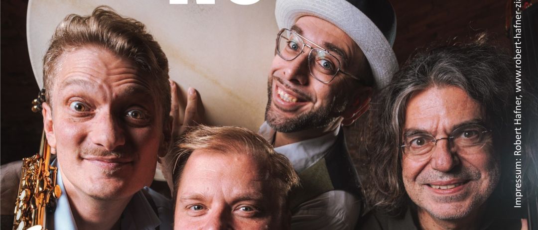 Vier Männer lächeln, einer hält eine Saxophon, ein anderer ein Schlagzeug, alle leger gekleidet. Die Worte 'Quartett zu Novo' sind prominent in weißem Text über ihnen angezeigt.