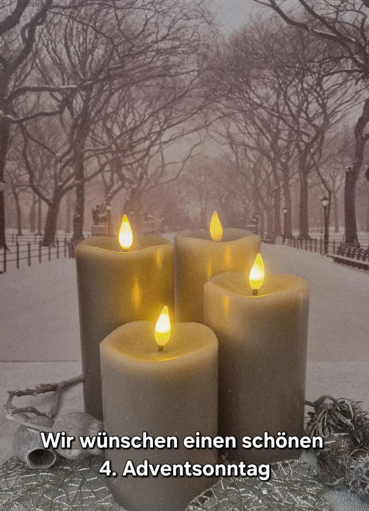 Vier brennende Kerzen auf einem verschneiten Pfad mit Bäumen und Bänken im Hintergrund. Die Szene ist ruhig und friedlich.