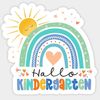 Ein Aufkleber zeigt einen farbenfrohen Regenbogen mit einem Herz in der Mitte, begleitet von einer lächelnden Sonne und Sternen, und die Worte 'Hallo Kindergarten' in bunten Buchstaben.