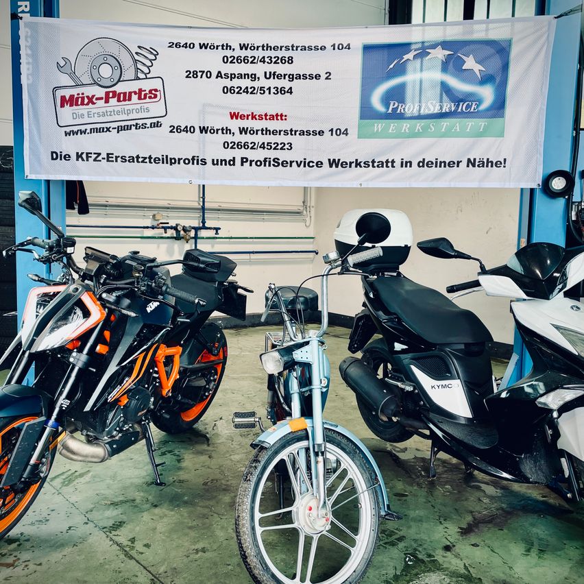 Ein Banner mit Kontaktinformationen hängt in einer Garage, wo drei Motorräder geparkt sind. Das Banner trägt den Namen Mix-Parts und bietet Kontaktdaten und eine Website an. Zu den Motorrädern gehören ein KTM, ein blaues und ein weißes KYMC.