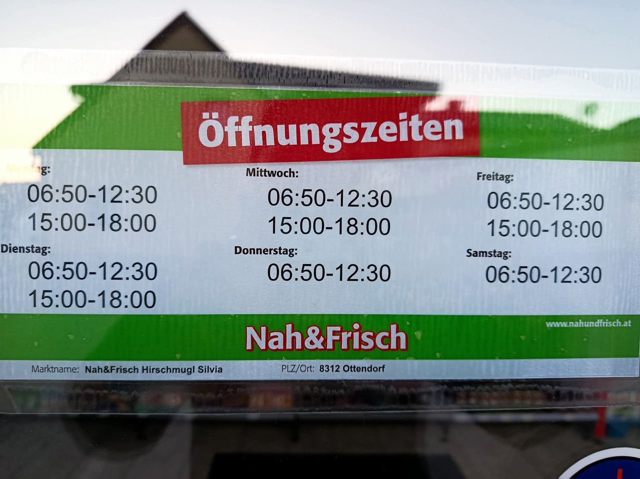 Ein Schild mit Öffnungszeiten für Nah&Frisch Hirschmugl Silvia, zeigt die Zeiten für Mittwoch, Donnerstag, Freitag, Samstag und Sonntag.