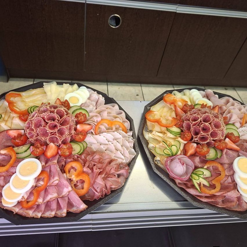Zwei Platten mit einer Vielfalt an Fleisch, Gemüse und Eiern, dekorativ angeordnet.