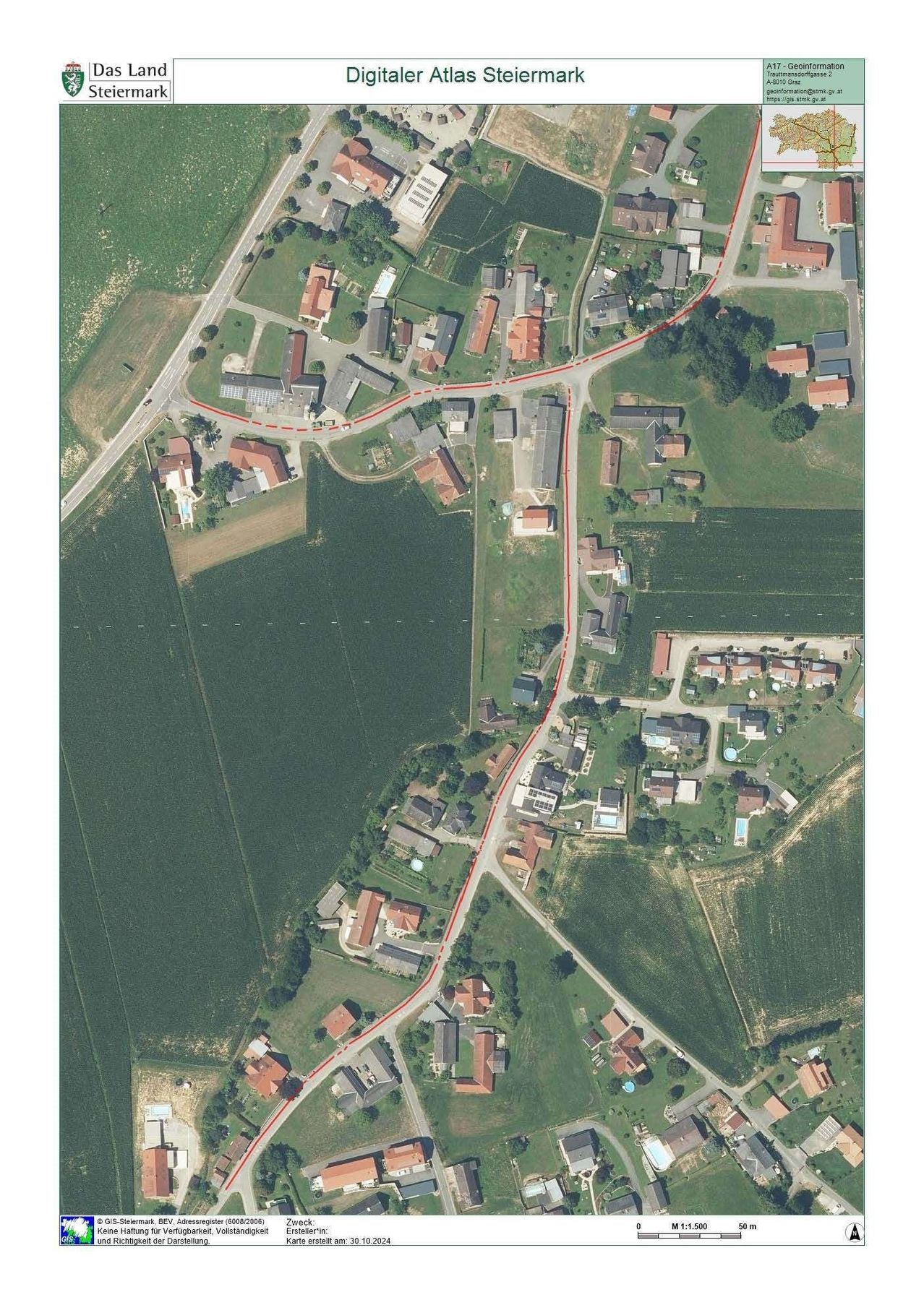 Eine Luftaufnahme eines ländlichen Gebiets mit mehreren Häusern und einer sich windenden roten Linie, die einen Weg anzeigt. Das Gebiet ist von grünen Feldern umgeben.