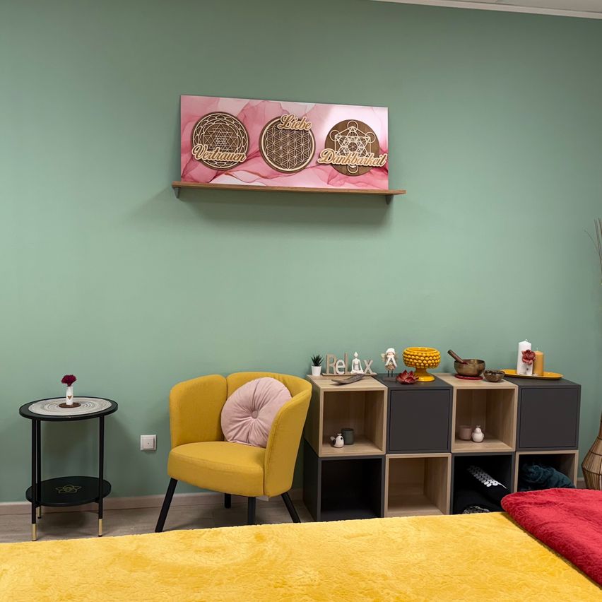 Ein gemütliches Zimmer mit einem gelben Stuhl und Bett, einer grünen Wand, einem Regal mit einem rosa Brett und verschiedenen Dekorationsartikeln.