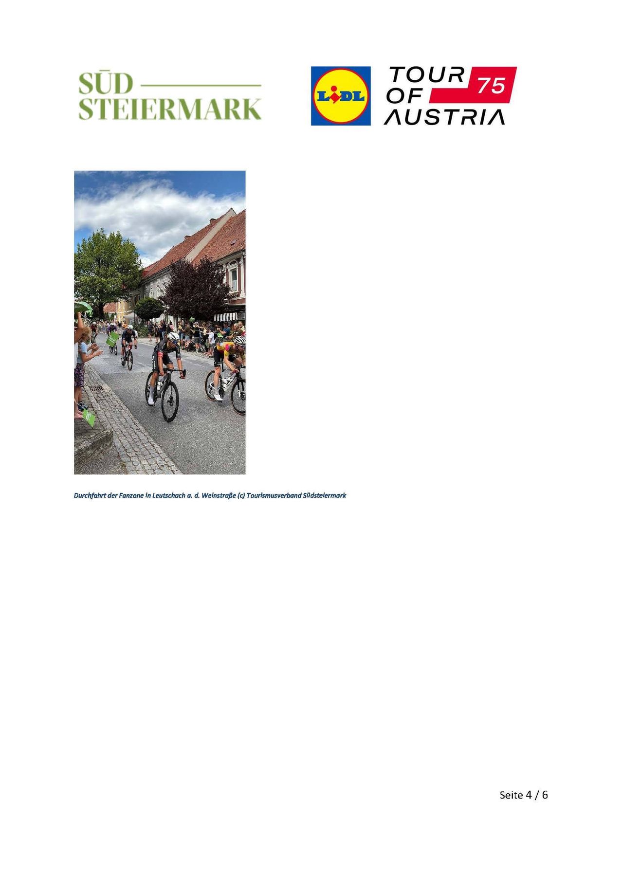 Eine Gruppe von Radfahrern fährt auf einer Straße in einer Stadt mit Zuschauern an der Seite.