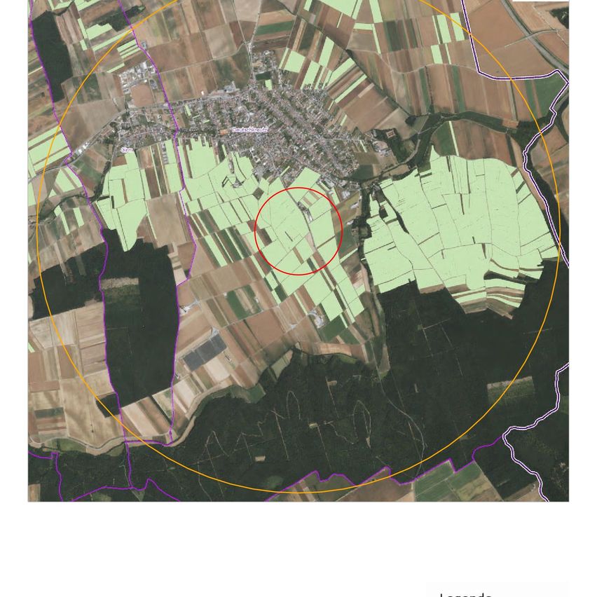 Aerial view of a rural area with green fields and a red circle highlighting a specific area.