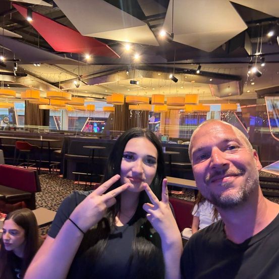 Ein Mann und eine Frau lächeln und posieren für ein Foto in einem Restaurant mit moderner Inneneinrichtung.