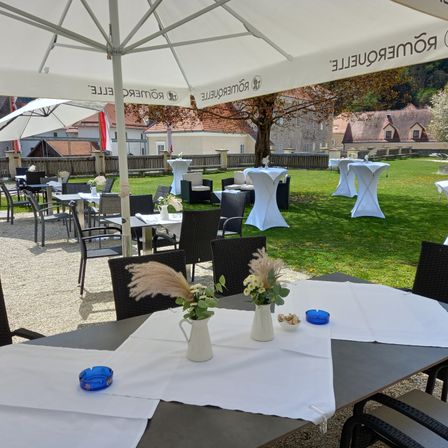 Bild enthält, Furniture, Table, Dining Table, Grass, Tabletop, Chair, Flower Arrangement, Restaurant, Patio Umbrella, Lawn
