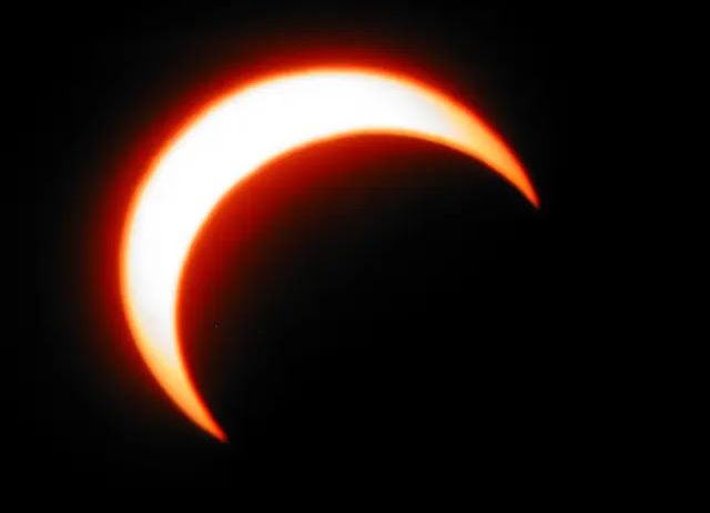 Ein Sonnenfinsternis ist im Gange, wobei der Mond teilweise die Sonne bedeckt und einen Feuerringeffekt erzeugt.