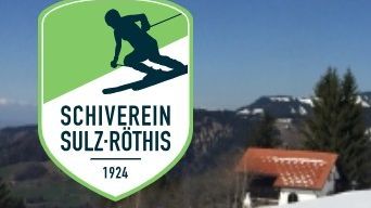 A ski resort logo shows a skier on a snowy slope with mountains in the background. The text reads 'SCHIVEREIN SULZ-ROTHIS 1924'. In the foreground, there is a house with a red roof and trees.