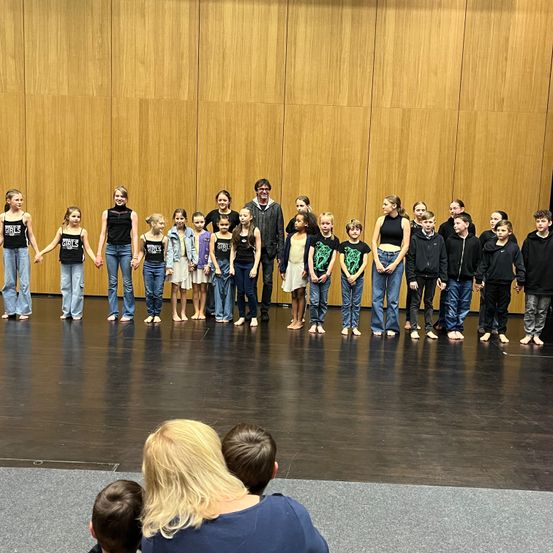 Pants, Interior Design, Person, People, Stage, Group Performance, Classroom, Coat, Crowd, Jeans
