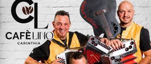 Drei Männer in gelben Westen spielen Instrumente in einem Café. Der Mann in der Mitte spielt Akkordeon, während der Mann auf der rechten Seite eine Gitarre hält. Der Mann auf der linken Seite spielt ein anderes Instrument. Der Text lautet 'Samstag, 8. August um 17 Uhr'.