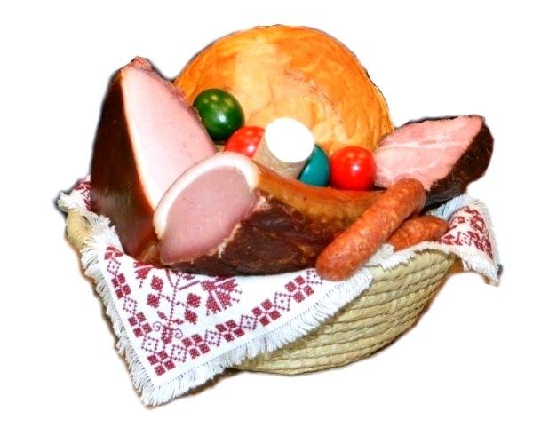 Ein Korb mit verschiedenen Wurstwaren, Brot und bunten Eiern, auf einem weißen Tuch mit rot-weißer Stickerei.