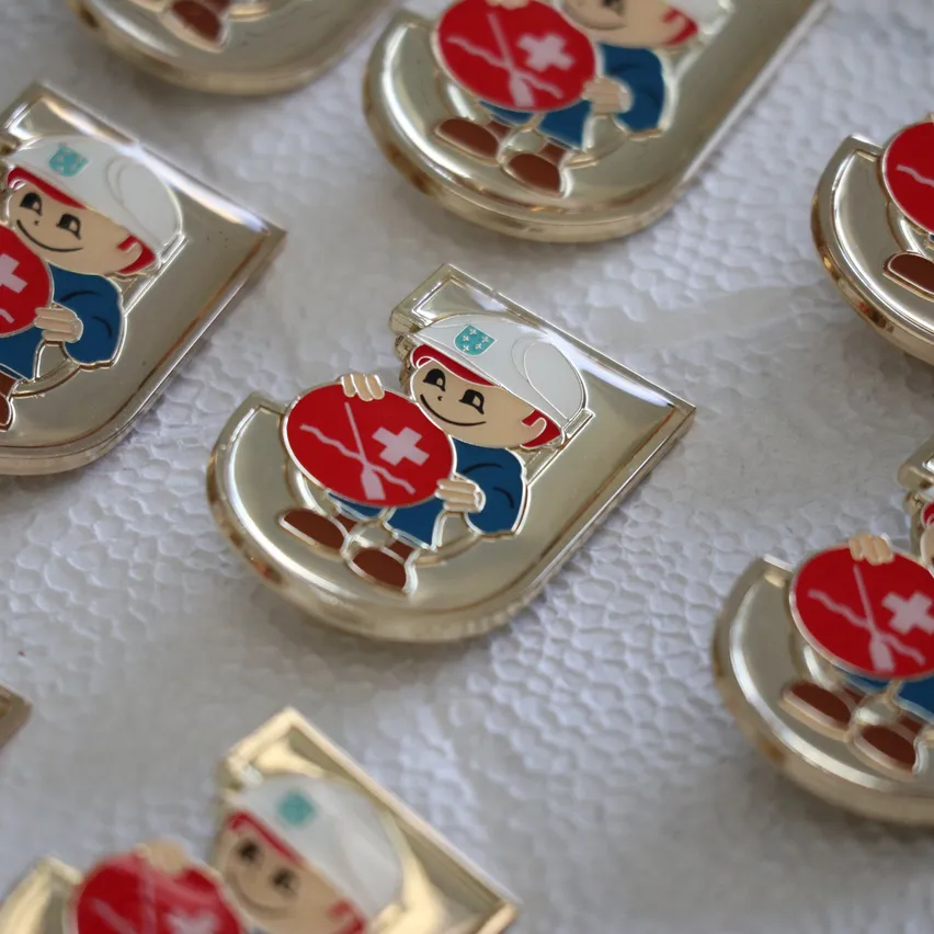 Eine Sammlung von goldplattierten Pins mit Zeichentrickfiguren, die ein rotes Kreuz halten.