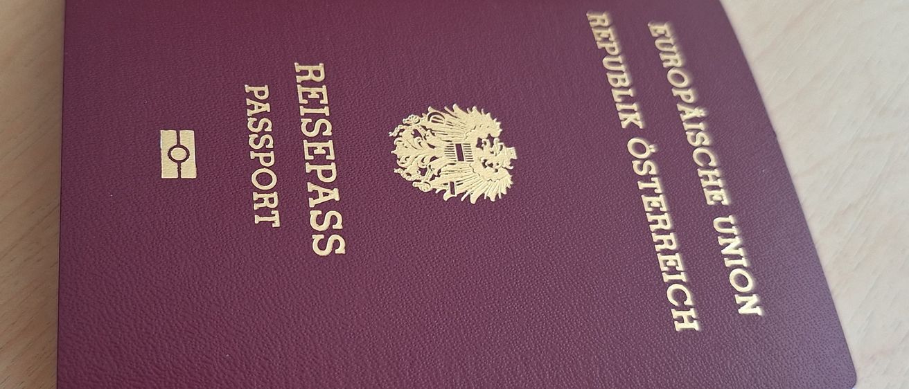 Ein burgunderroter Reisepass mit der Aufschrift 'Reisepass' von der Republik Österreich, Europäische Union. Der Einband hat goldenen Text und ein goldenes Emblem.