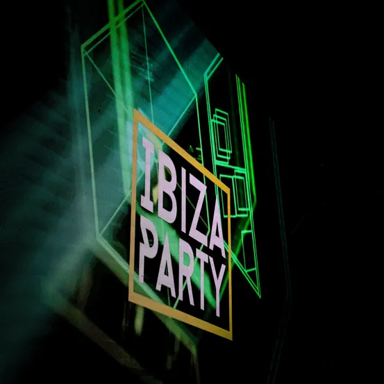 Ein leuchtendes Neonschild mit der Aufschrift 'IBIZA PARTY' wird auf einem dunklen Hintergrund mit geometrischen Formen und leuchtend grünen Umrissen angezeigt. Das Schild wird von einem hellen Licht beleuchtet und wirft Reflexionen in der Umgebung.