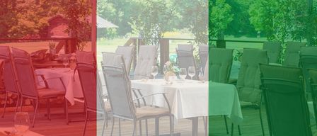 Ein Restaurant im Freien mit gedeckten Tischen, umgeben von üppigem Grün und einer entfernten Aussicht auf ein Feld.