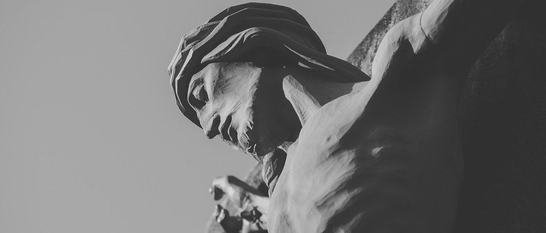 Ein Schwarz-Weiß-Foto zeigt eine detaillierte Skulptur von Jesus am Kreuz, mit Fokus auf Kopf und Oberkörper.