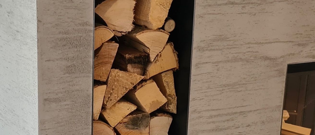 Ein Stapel Holzscheite, ordentlich gestapelt und bereit für den Gebrauch, wobei einige Stücke Anzeichen von Abnutzung zeigen.