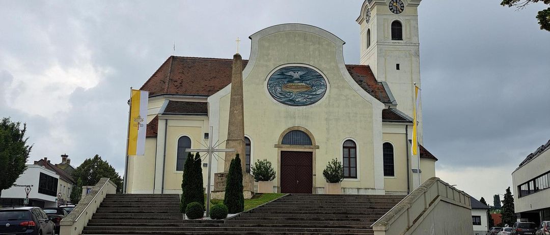 Eine Kirche mit Glockenturm und einem Turm steht in der Mitte der Straße.