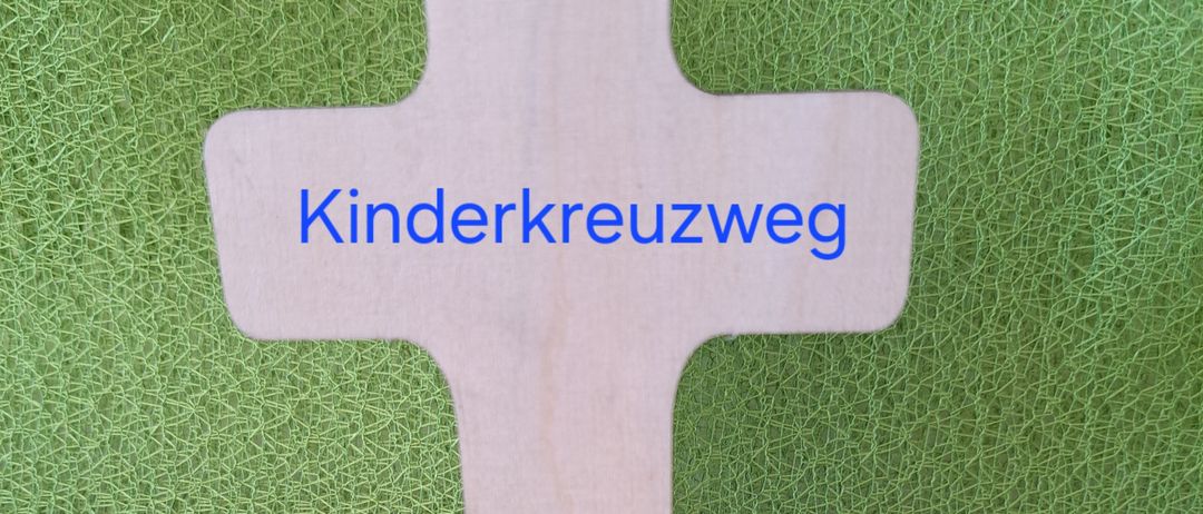 Ein hölzernes Kreuz mit dem Text 'Kinderkreuzweg' auf grünem Hintergrund, begleitet von einer gelben Blume und grünen Blättern.