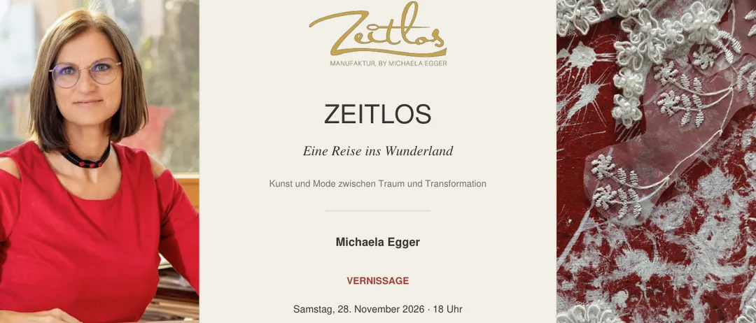 Eine Frau in einem roten Shirt sitzt an einem Tisch mit Papieren und Stoff.