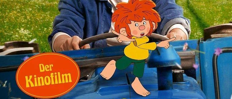 Ein lächelnder Mann hält ein Lenkrad, mit einer gezeichneten Figur, die auf einen blauen Traktor zeigt. Der Name der Figur, Pumuckel, ist prominent angezeigt.