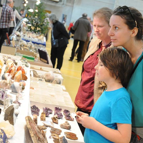 Mineralienbrse_FraumitKind_StehendvorMineralien_Stand_JarmerMargarete(2)