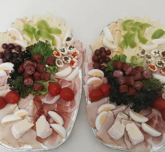 Zwei Tabletts mit einer Vielfalt an Lebensmitteln, einschließlich Eier, Fleisch, Gemüse und Gewürzen.